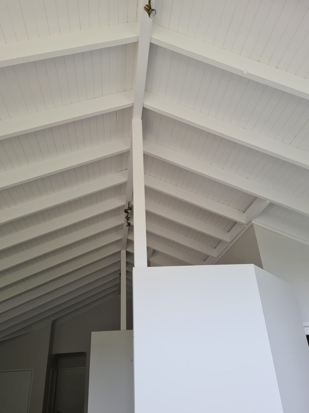 Cathedral ceiling with exposed rafters painted in a clean white finish