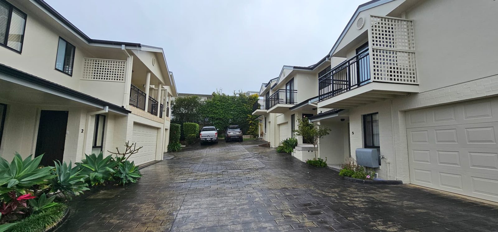 Driveway between two rows of freshly repainted townhouses